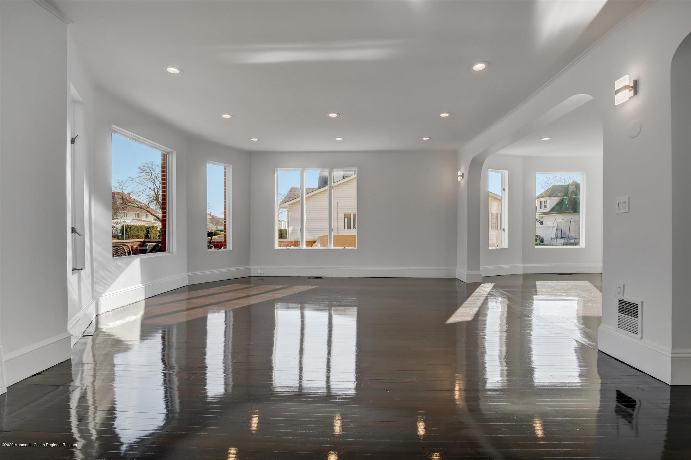 a large white kitchen with granite countertop a large window