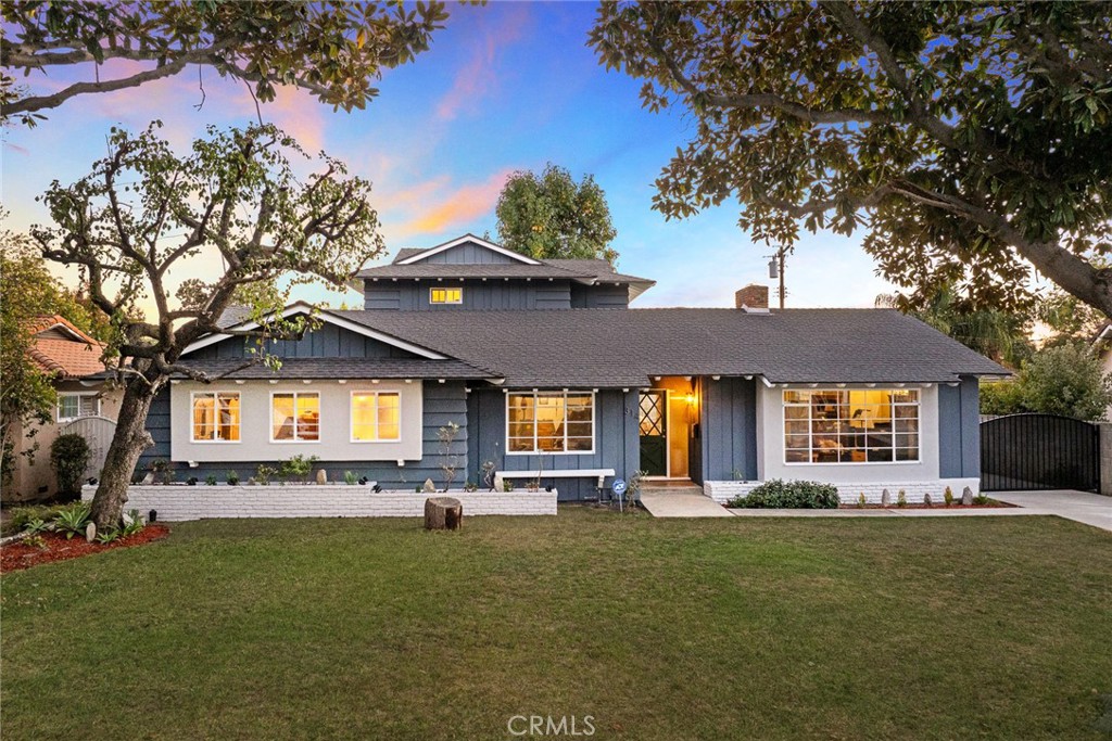 a front view of house with a garden