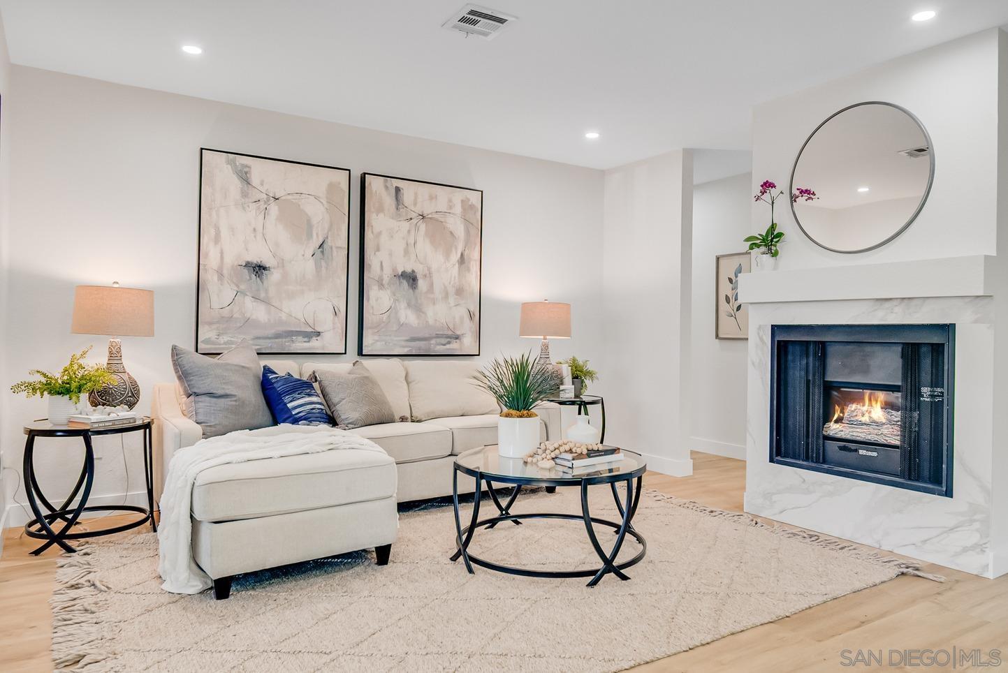 a living room with furniture a fireplace and a large mirror