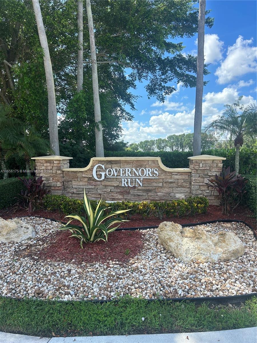 a view of a sign in a yard with potted plants