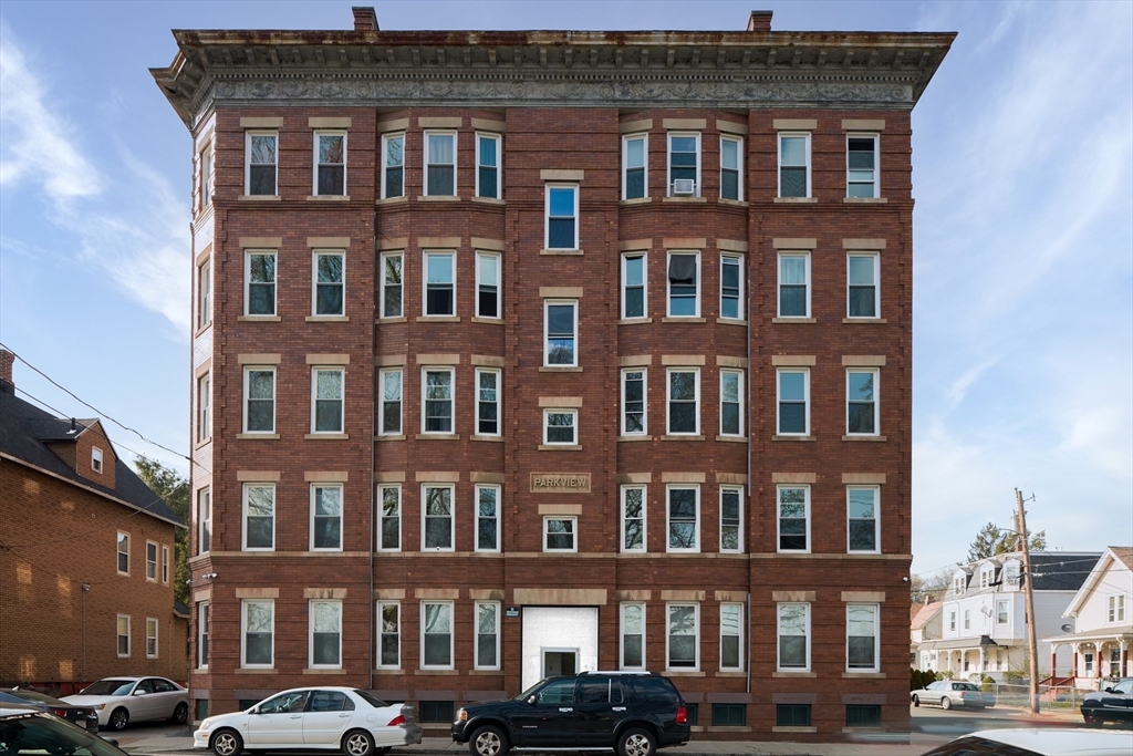 a front view of a residential apartment building with a yard