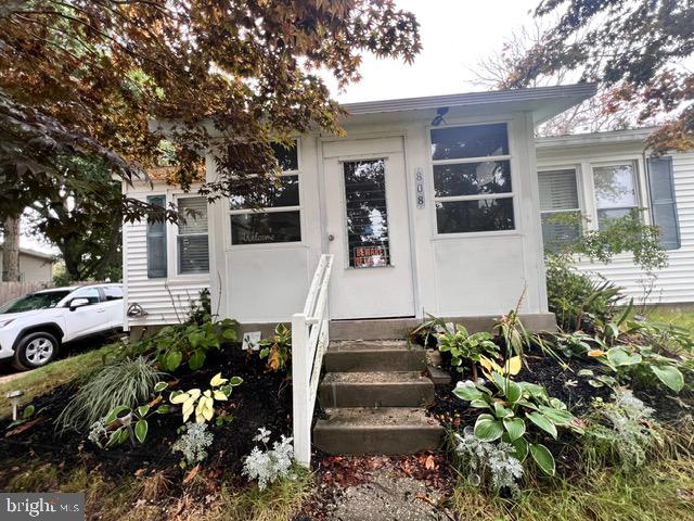 a front view of a house with a yard and potted plants