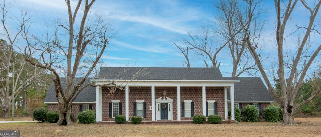 front view of a brick house with a yard