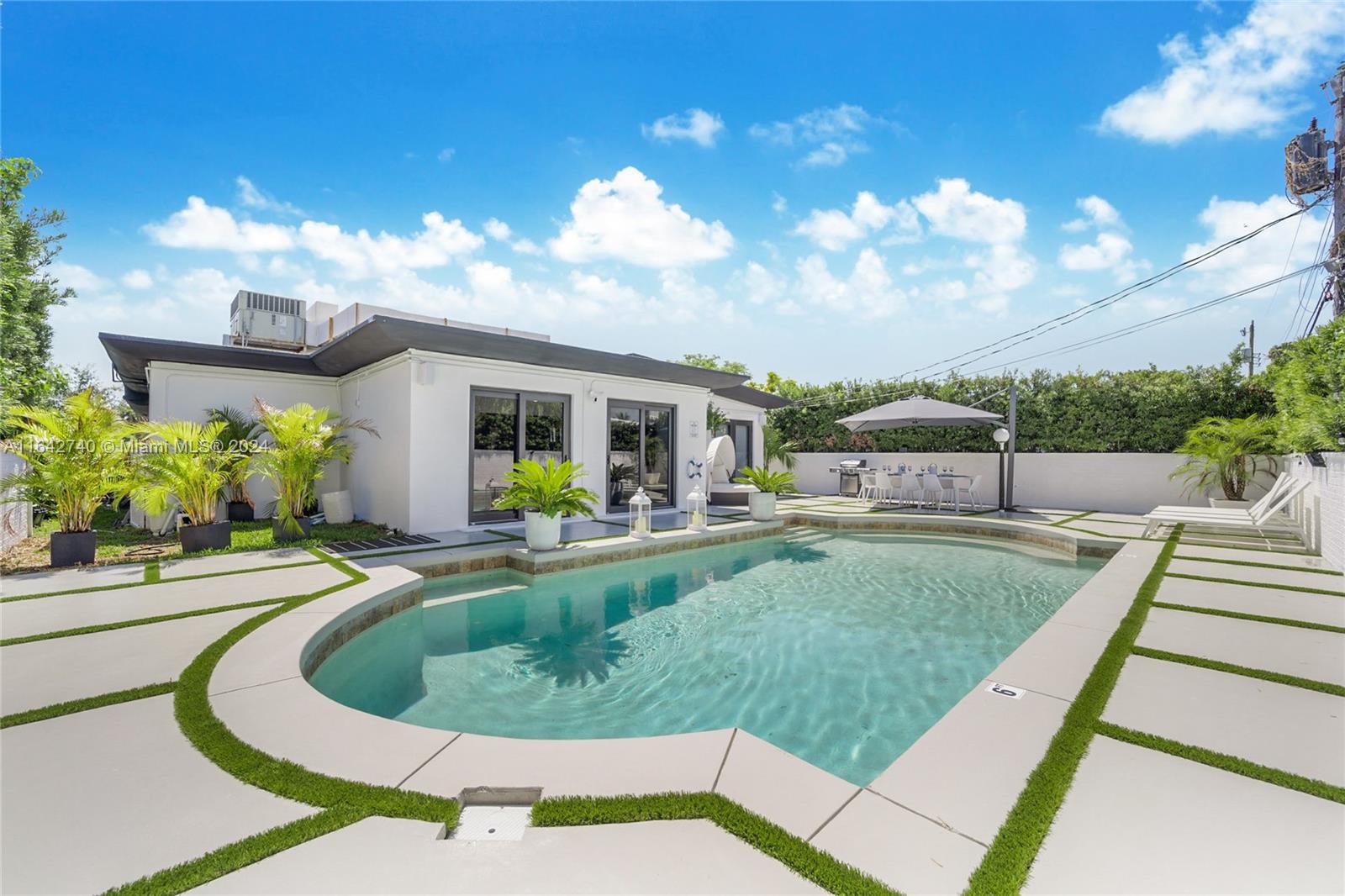 a view of a house with backyard and sitting area