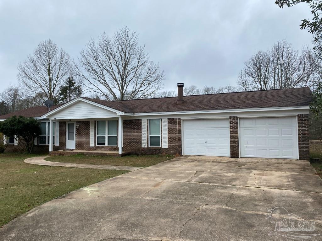 a front view of a house with a yard and trees