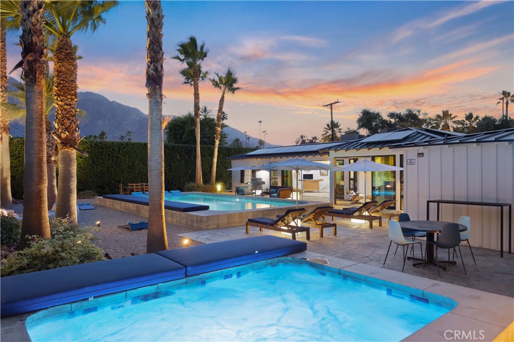 a view of a house with swimming pool and sitting area