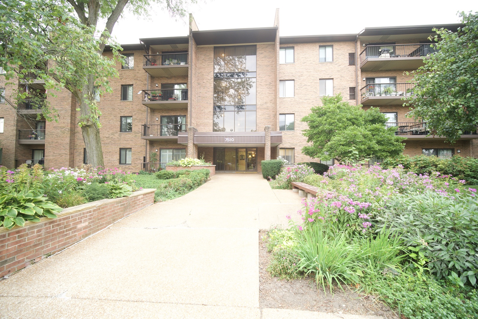 a front view of a building with a garden and plants