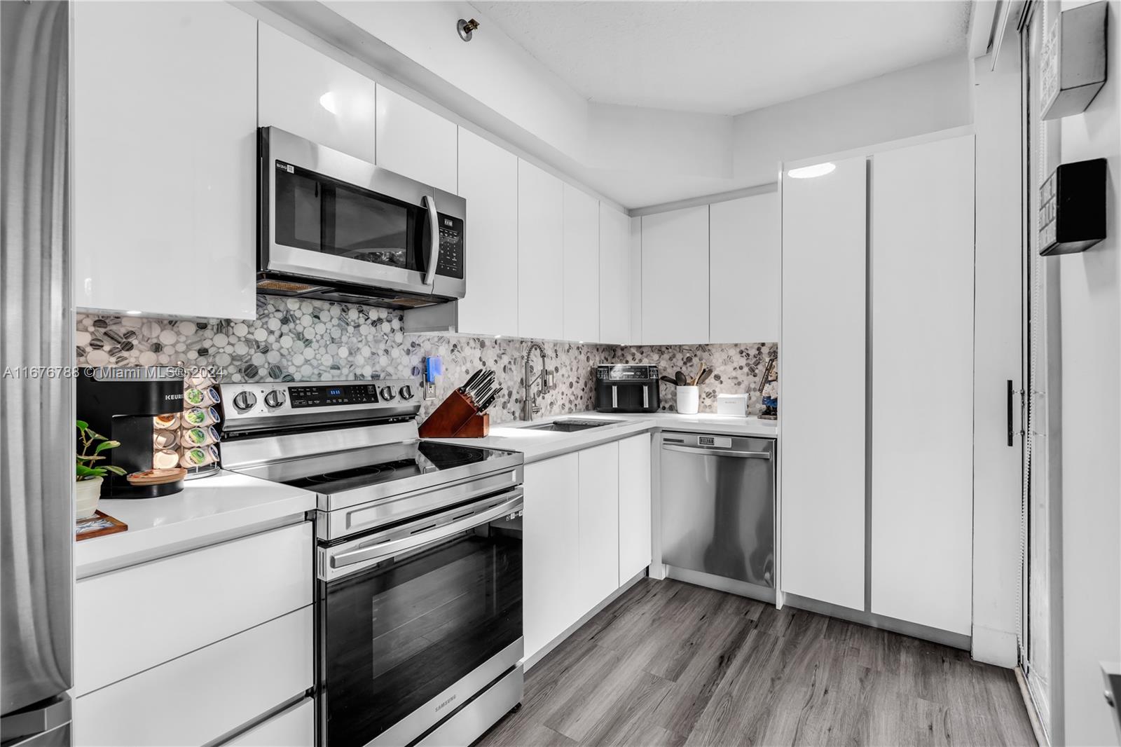 a kitchen with stainless steel appliances white cabinets and a stove top oven