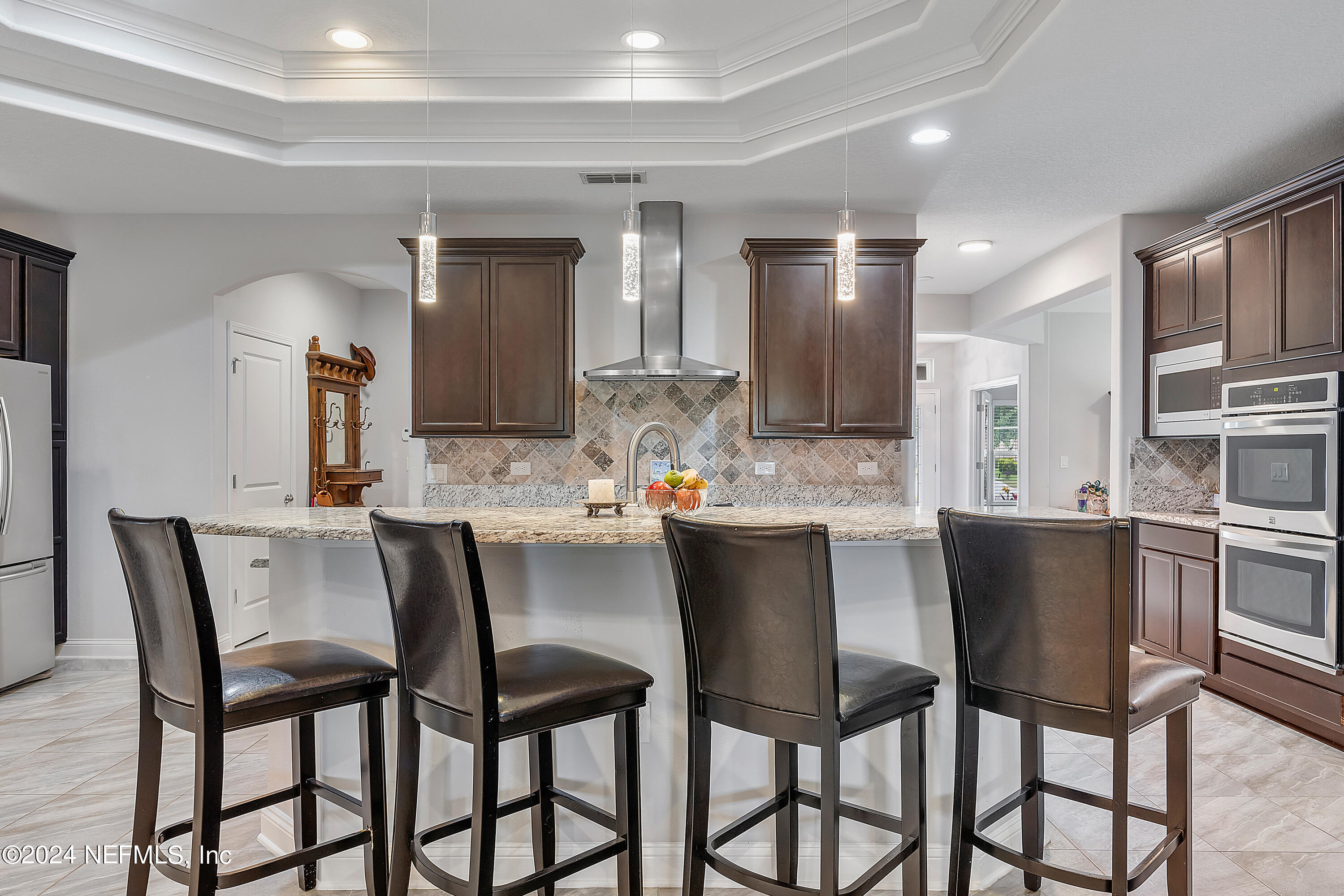 a kitchen with a dining table chairs sink and cabinets