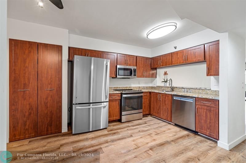 a kitchen with granite countertop stainless steel appliances a refrigerator and a sink