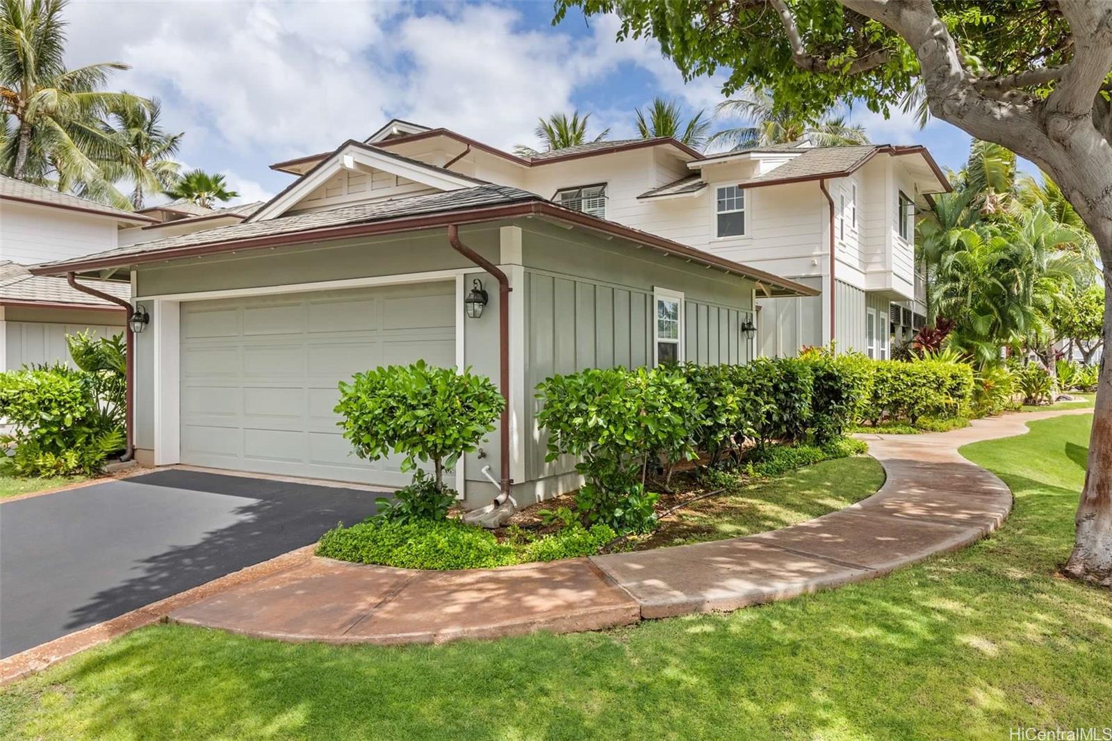 a front view of a house with a yard and potted plants