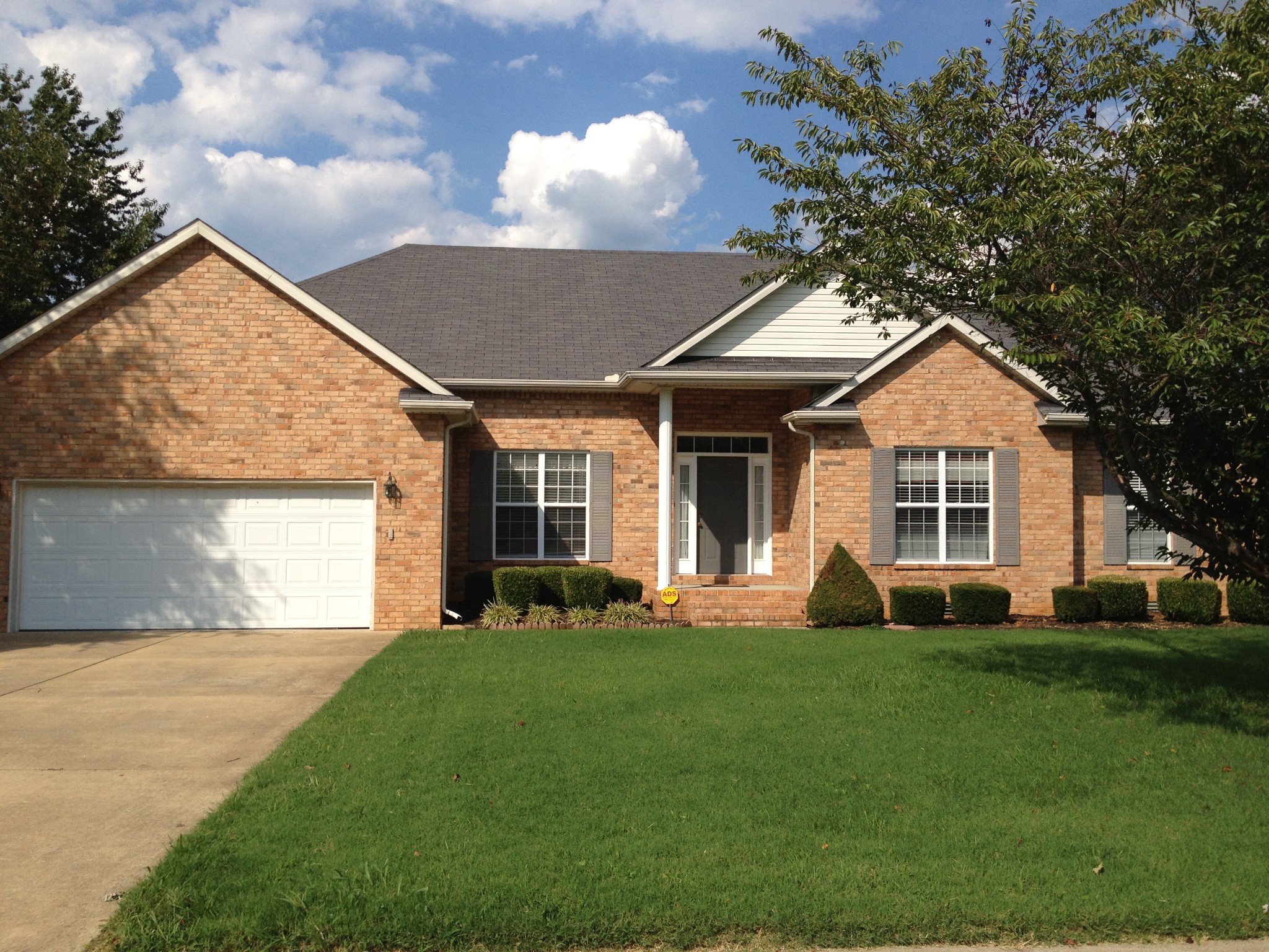 a front view of a house with a yard and trees