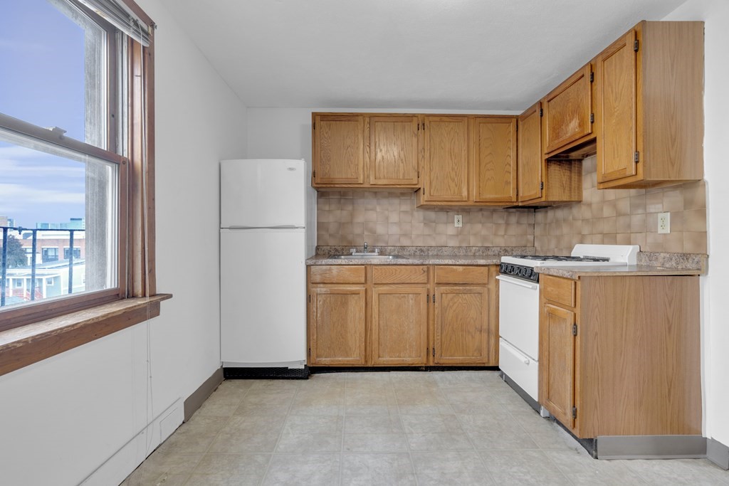 a kitchen with granite countertop white cabinets and white appliances