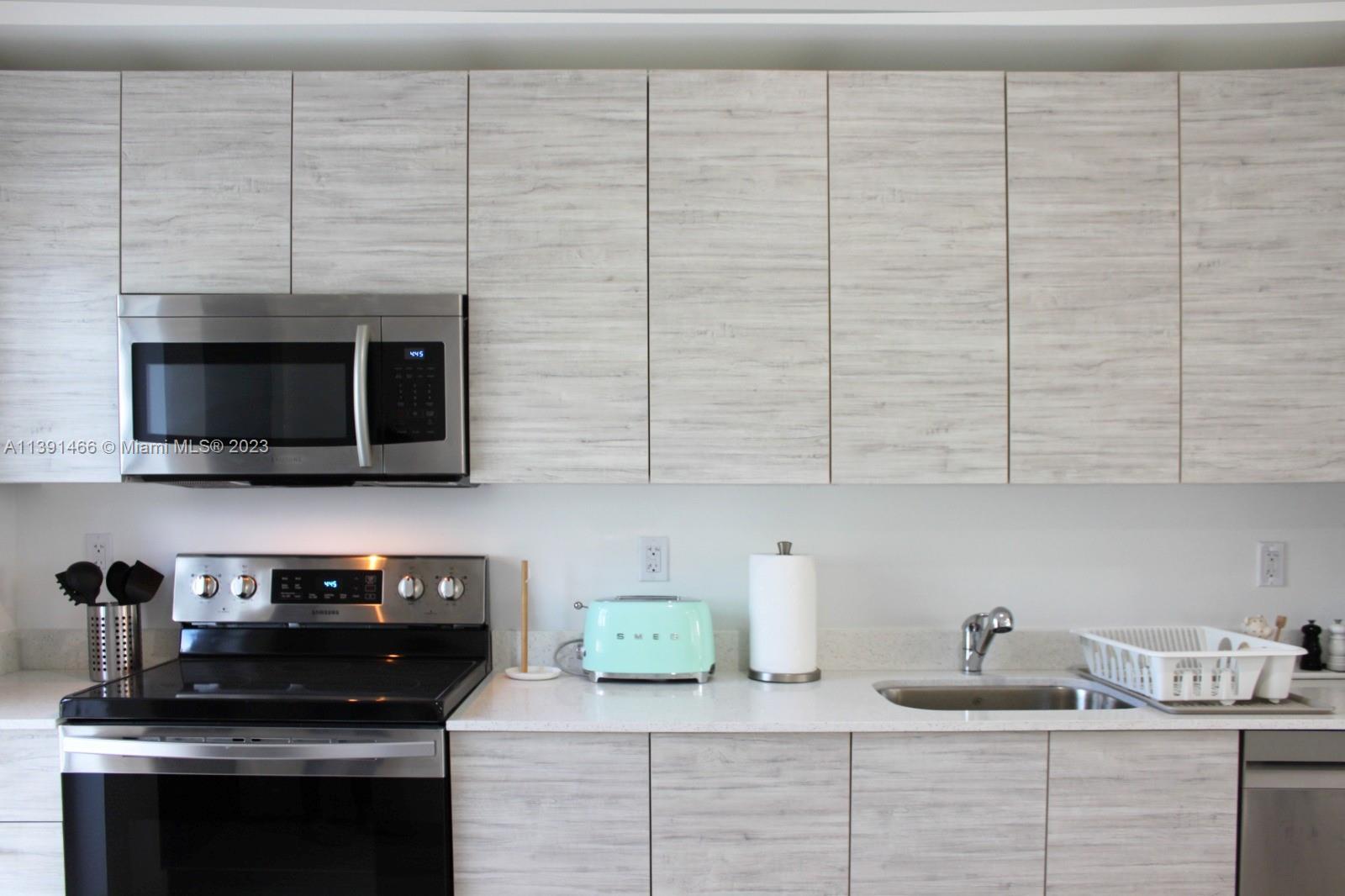 a kitchen with stainless steel appliances a sink stove and cabinets