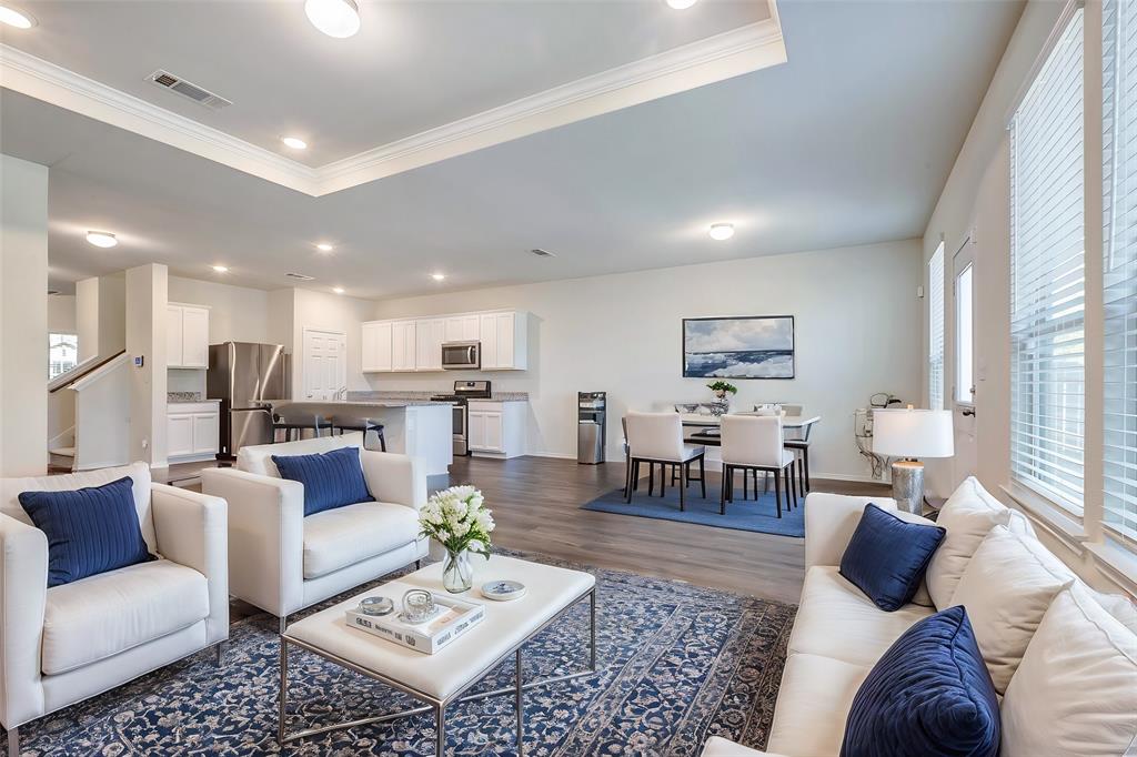 a living room with furniture kitchen view and a large window