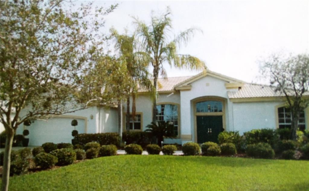 a front view of a house with a garden and plants