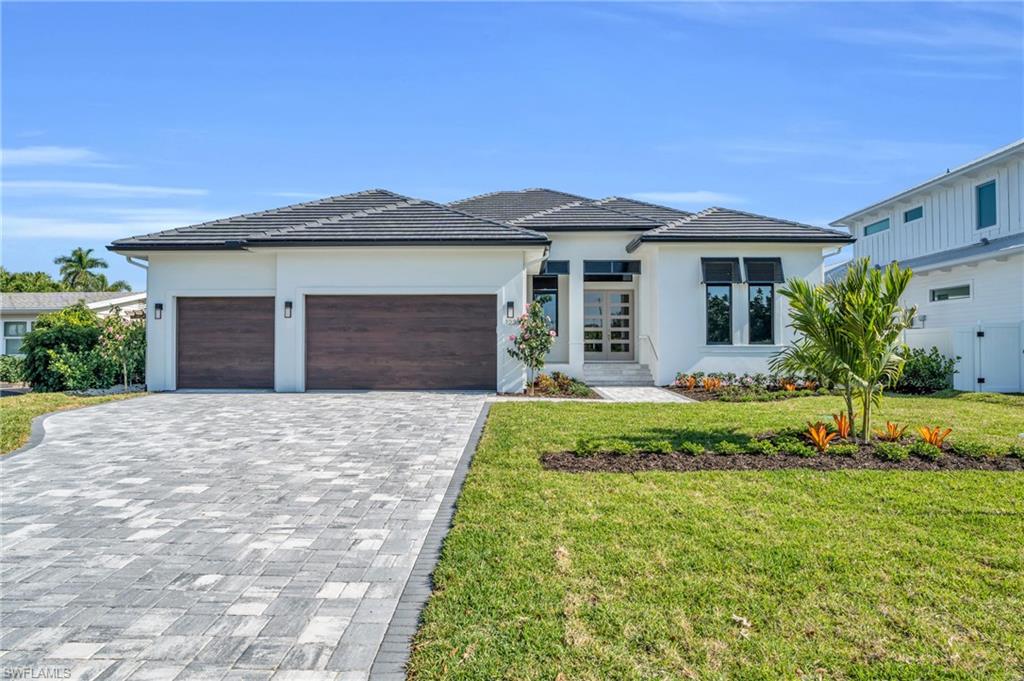 a front view of a house with a yard and garage