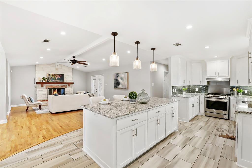 a large kitchen with kitchen island a large counter space a sink appliances and cabinets