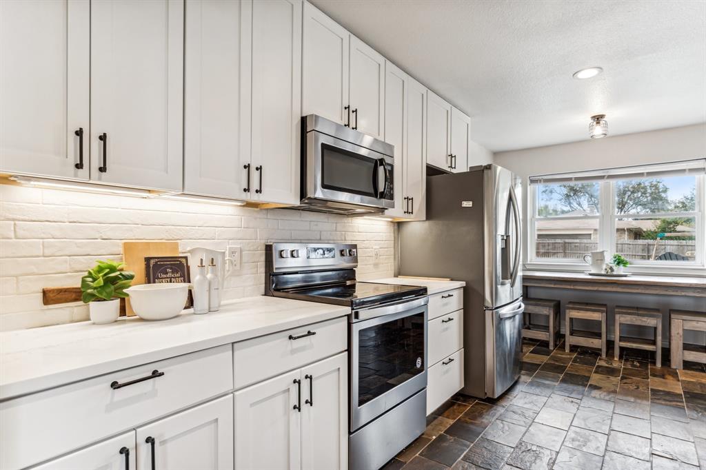 a kitchen with stainless steel appliances a stove microwave and cabinets