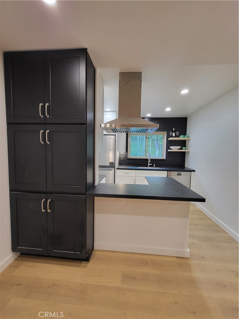 a kitchen with kitchen island a counter top space cabinets and stainless steel appliances