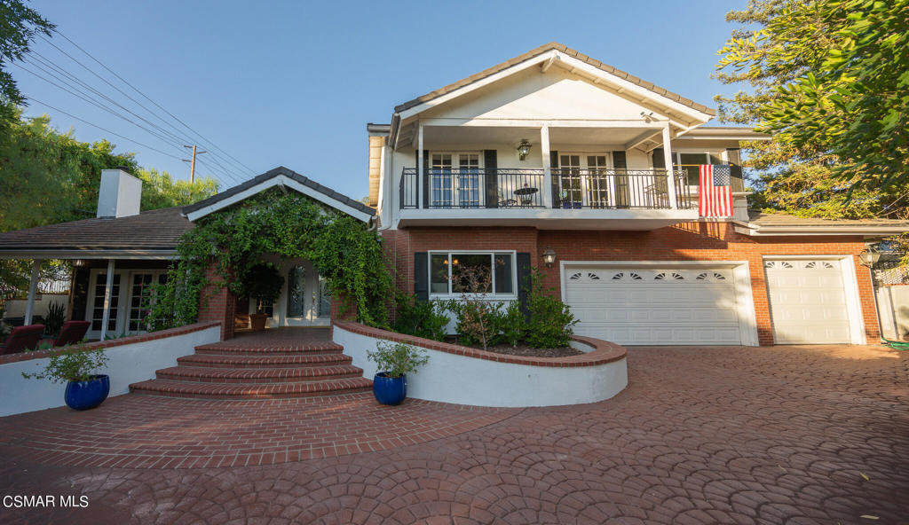 a front view of a house with a yard and potted plants