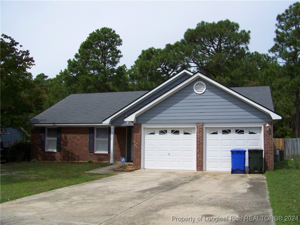 a front view of a house with a garden and trees