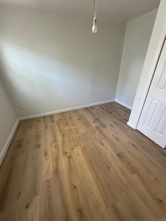 Unfurnished bedroom area featuring hardwood / wood-style flooring