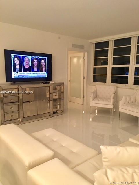 a living room with furniture cabinets and a flat screen tv