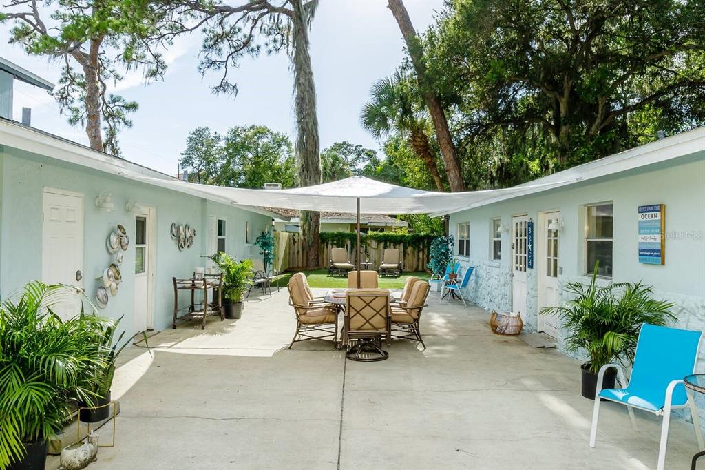 a view of a patio with table and chairs under an umbrella