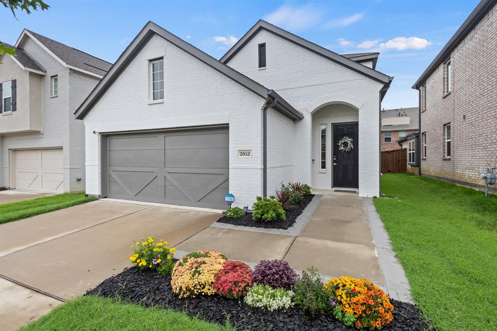 a front view of a house with a yard and flowers