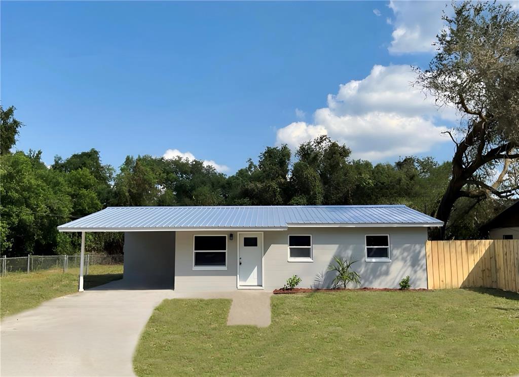 a front view of house with yard and trees in the background