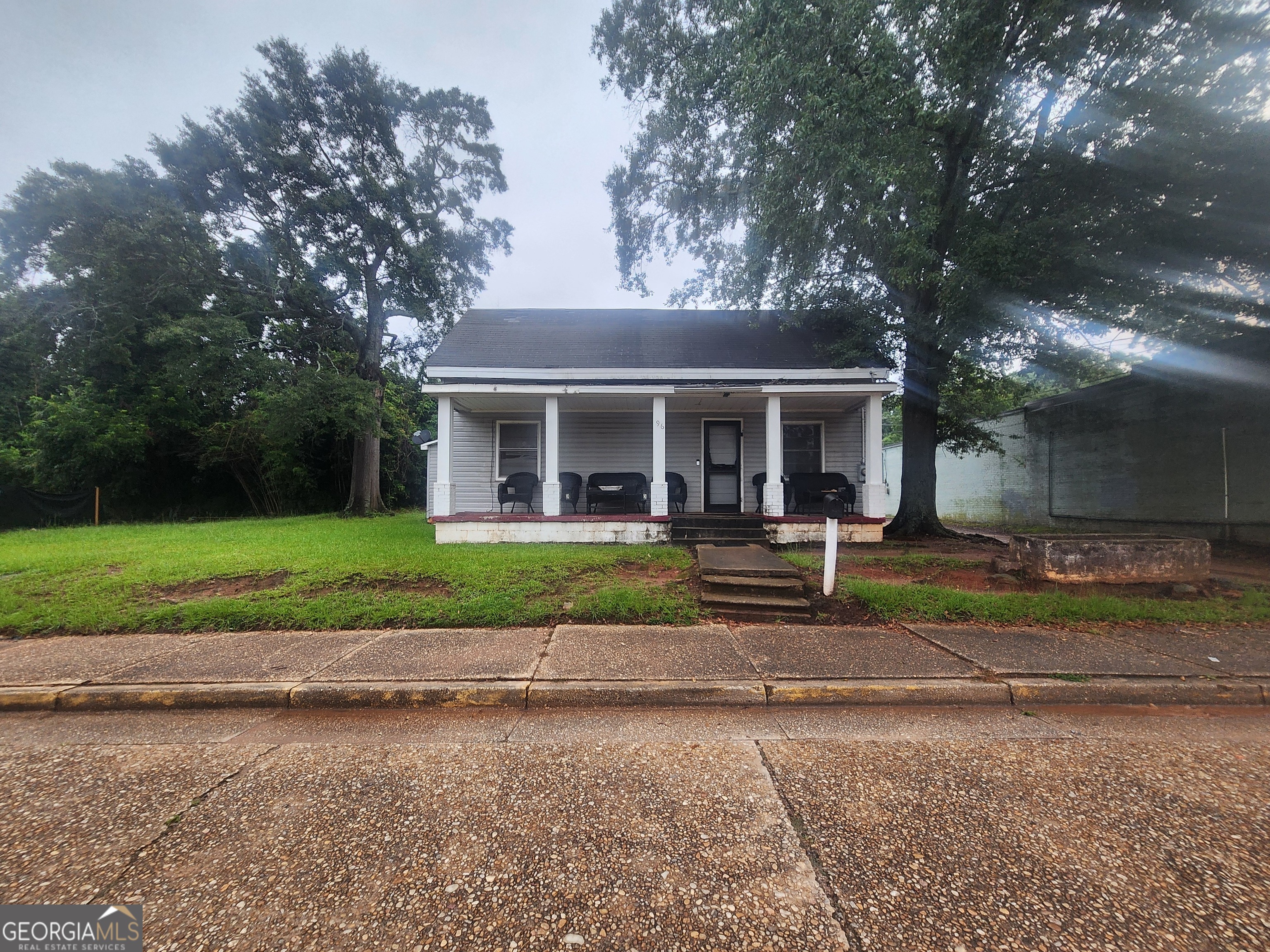 a view of house in front of a yard with potted plants