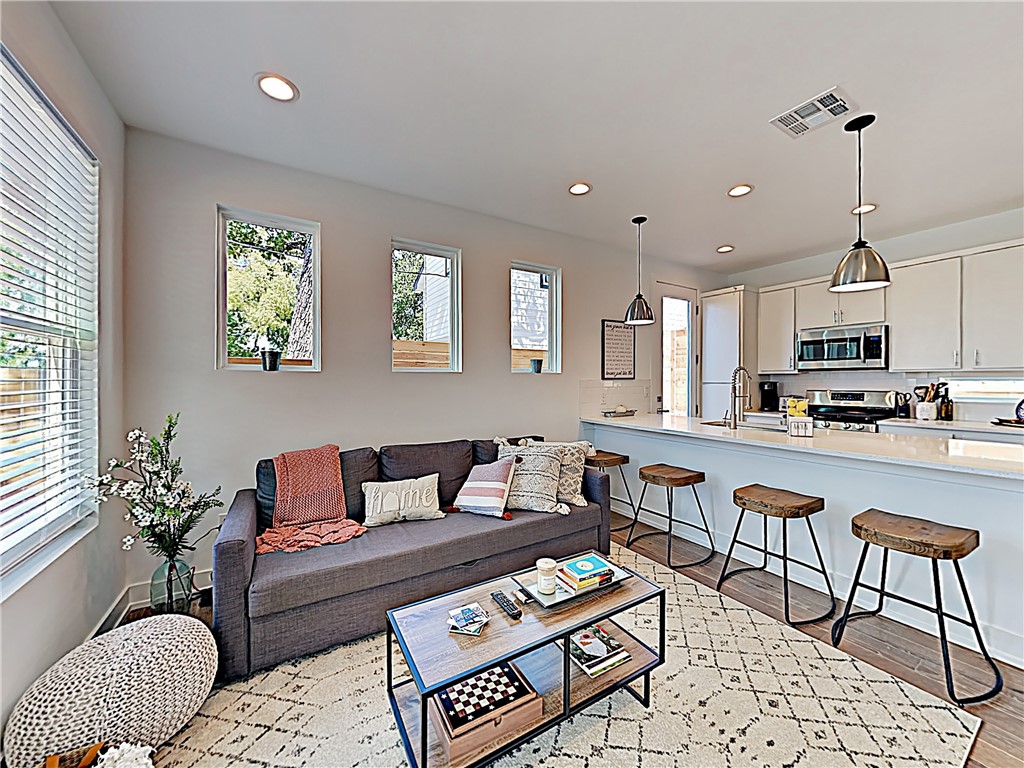 a living room with furniture and a dining table with kitchen view