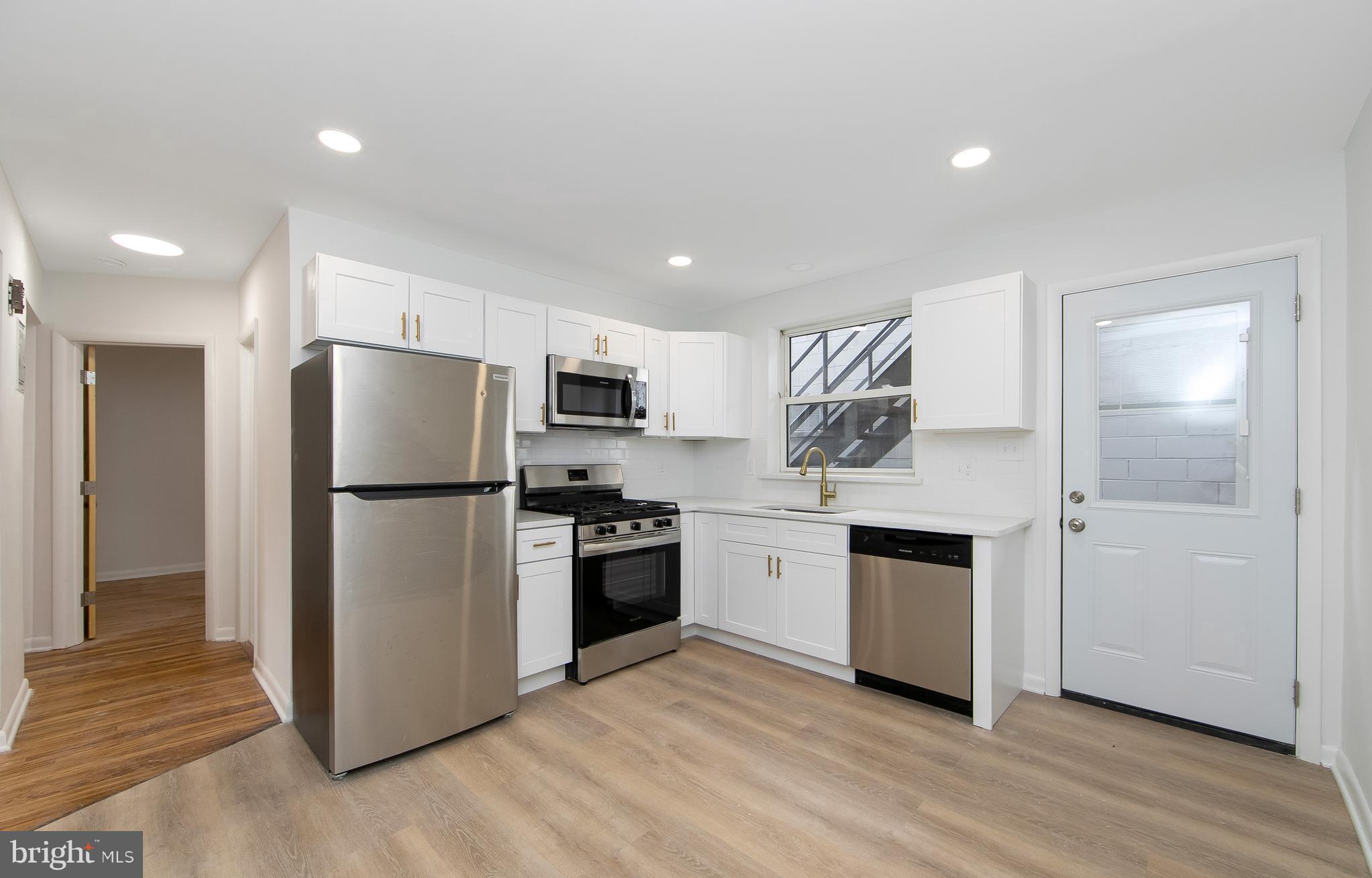 a kitchen with a refrigerator and a stove top oven