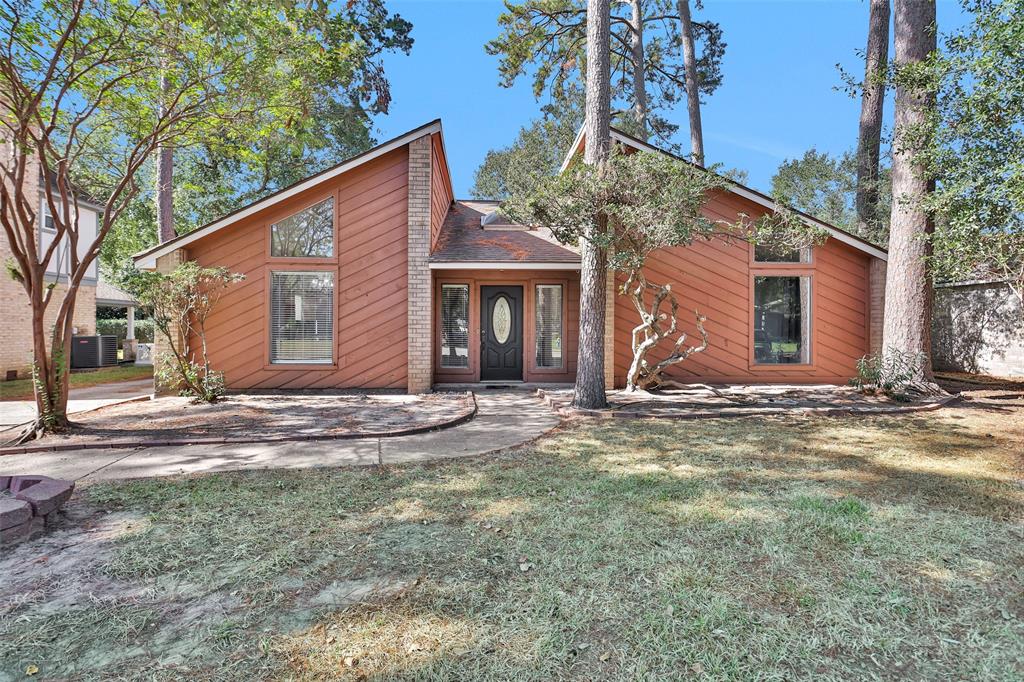 a view of a house with backyard and trees