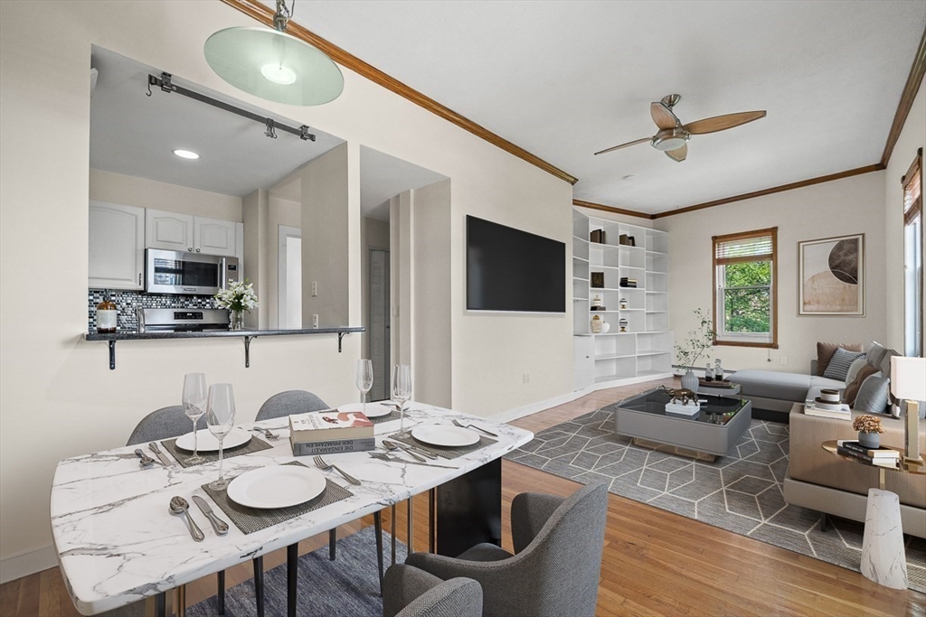 a living room with stainless steel appliances kitchen island granite countertop furniture and a flat screen tv