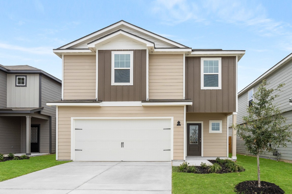 a front view of a house with a yard and garage