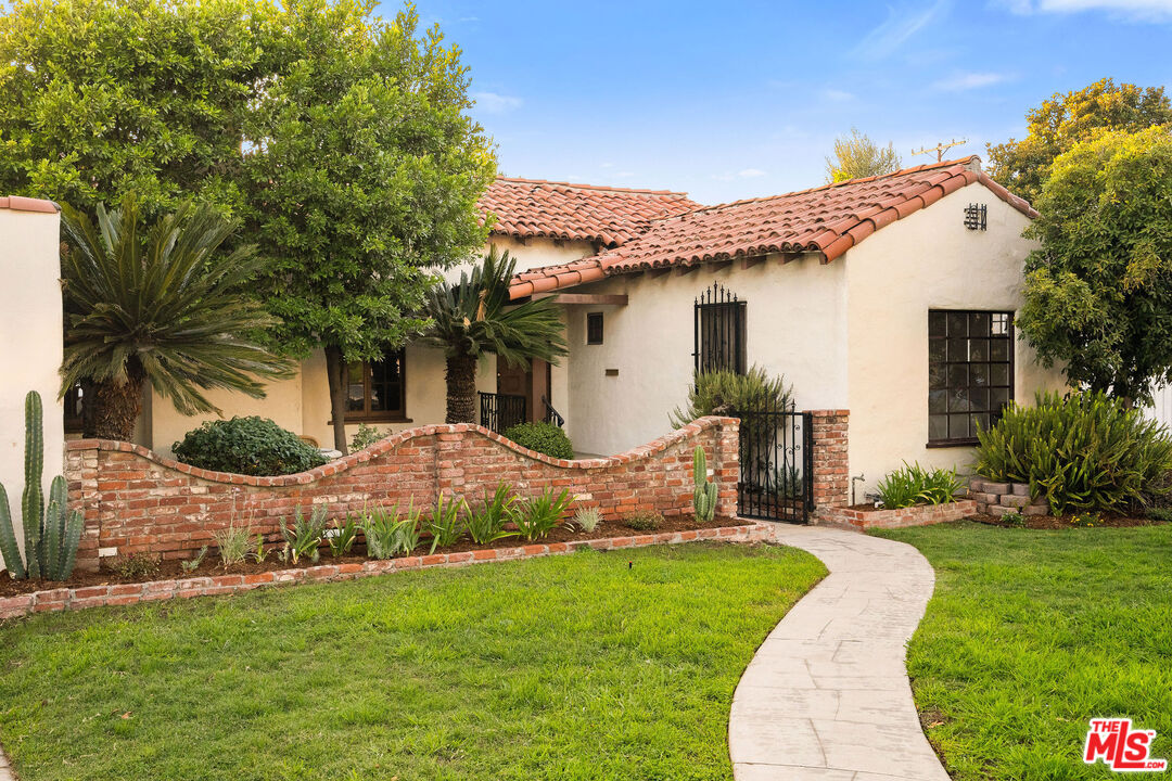 a view of a house with a yard and potted plants