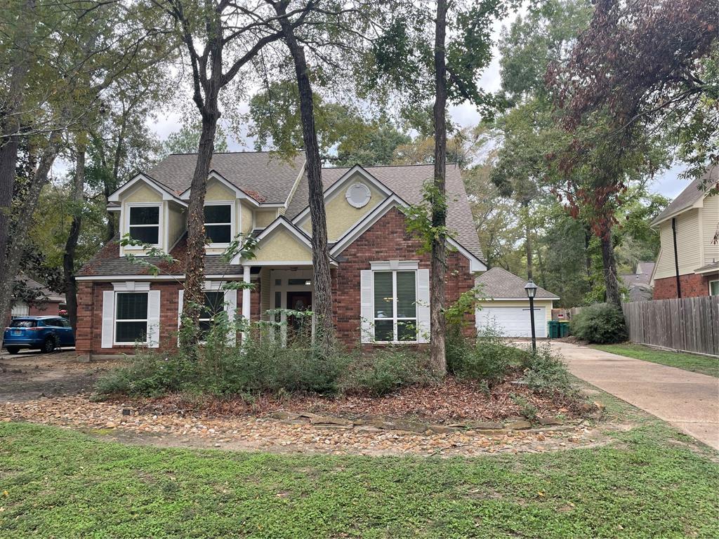 a front view of a house with a yard and trees