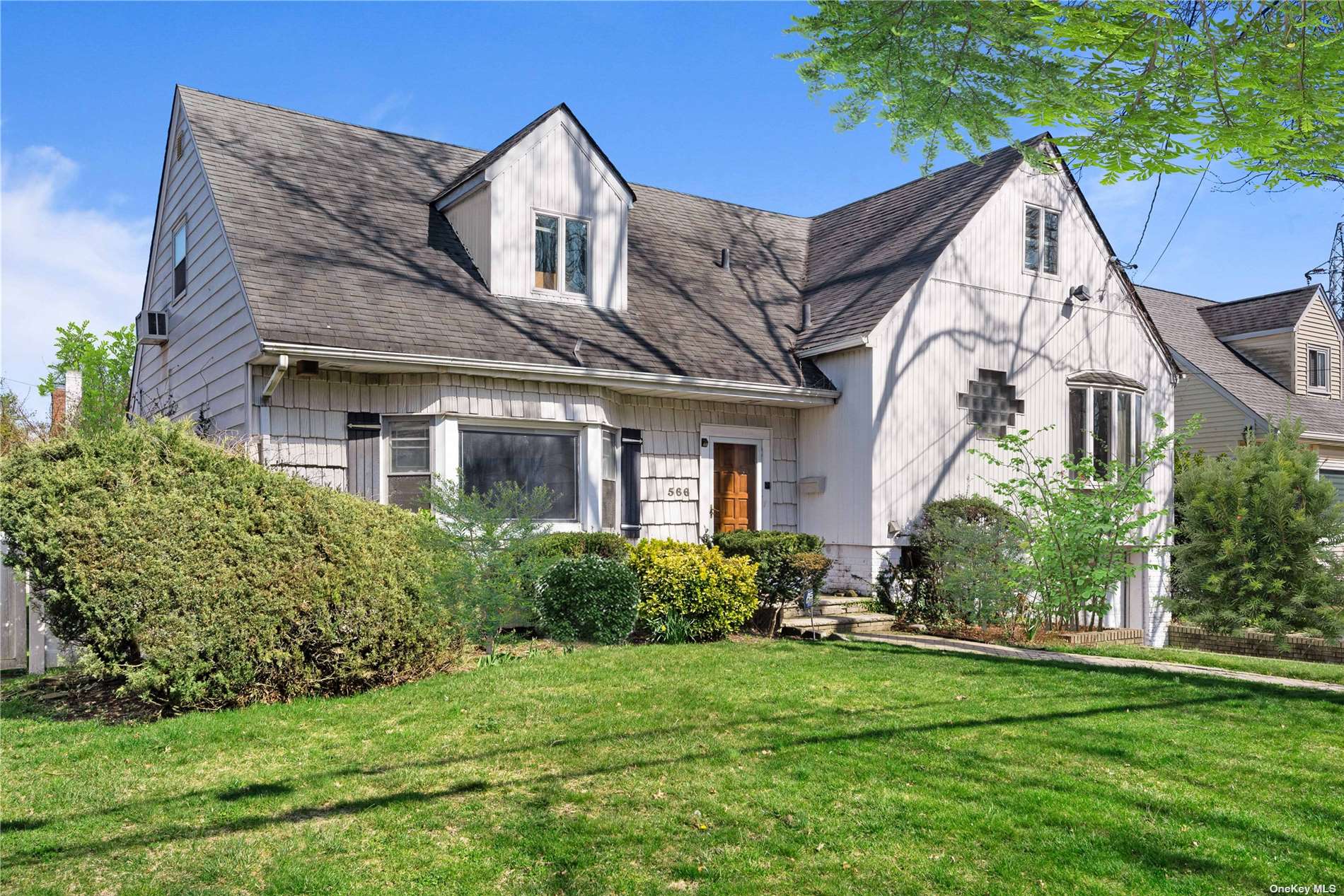 a front view of a house with a yard and potted plants