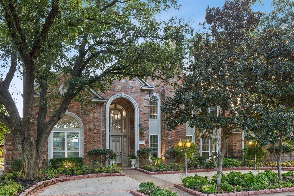 front view of a brick house with a tree