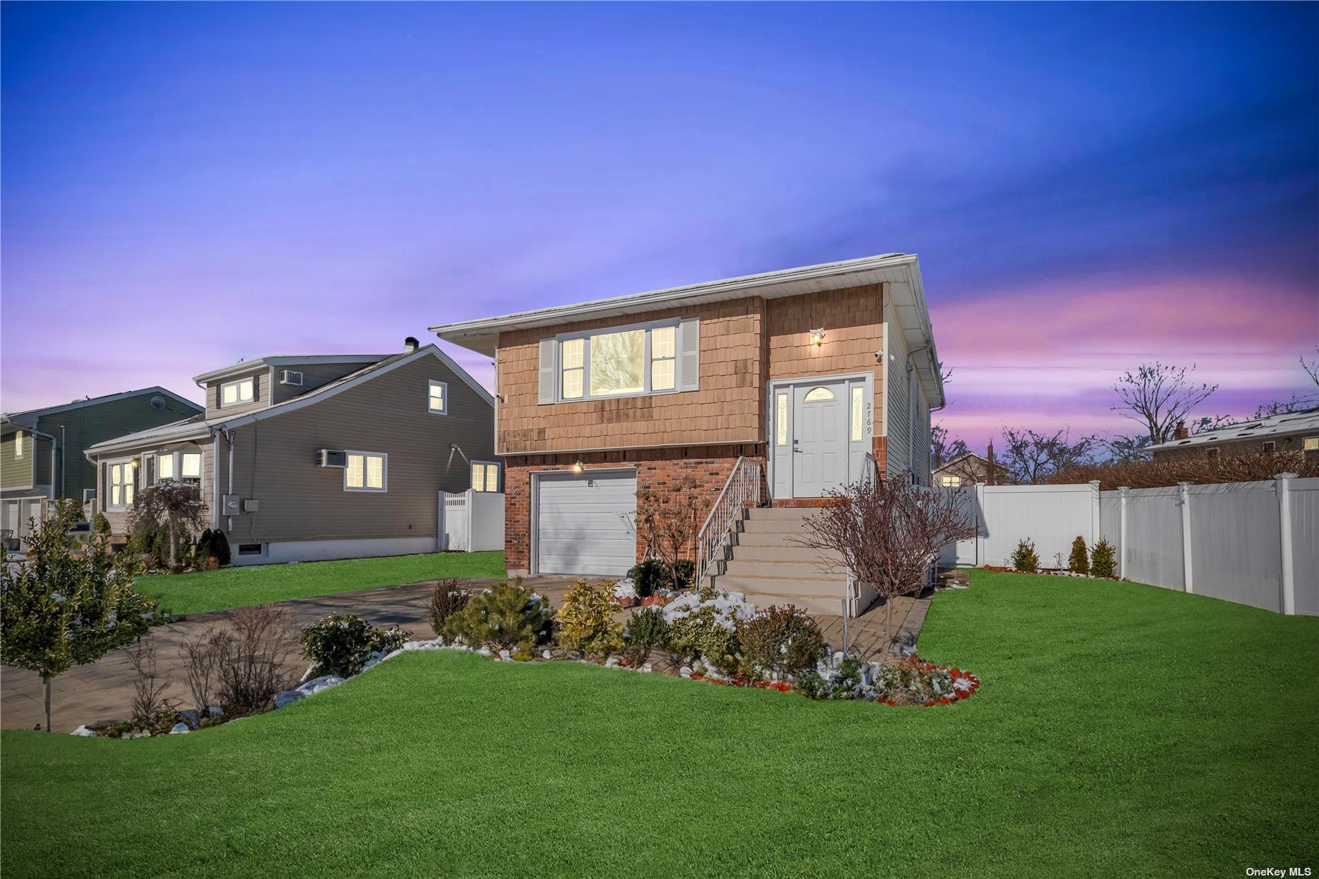 a front view of a house with a garden and yard