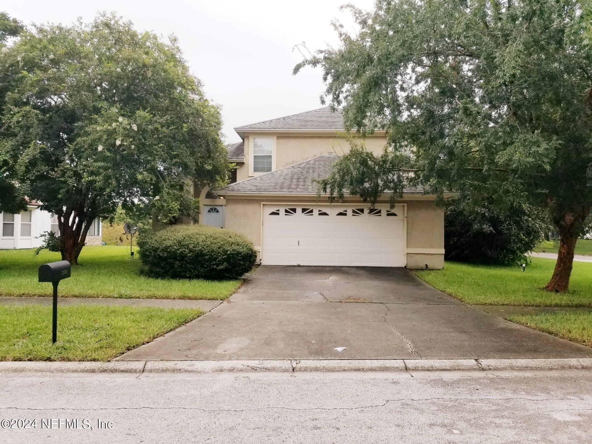 a view of a house with a yard and garage