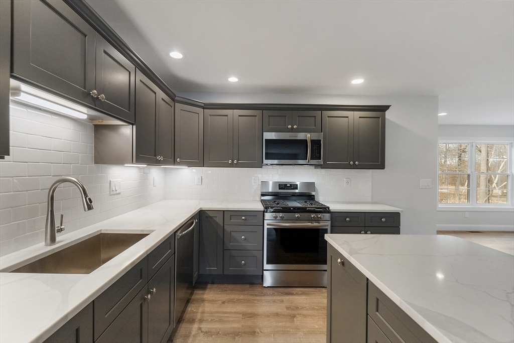 a kitchen with a sink stainless steel appliances and cabinets