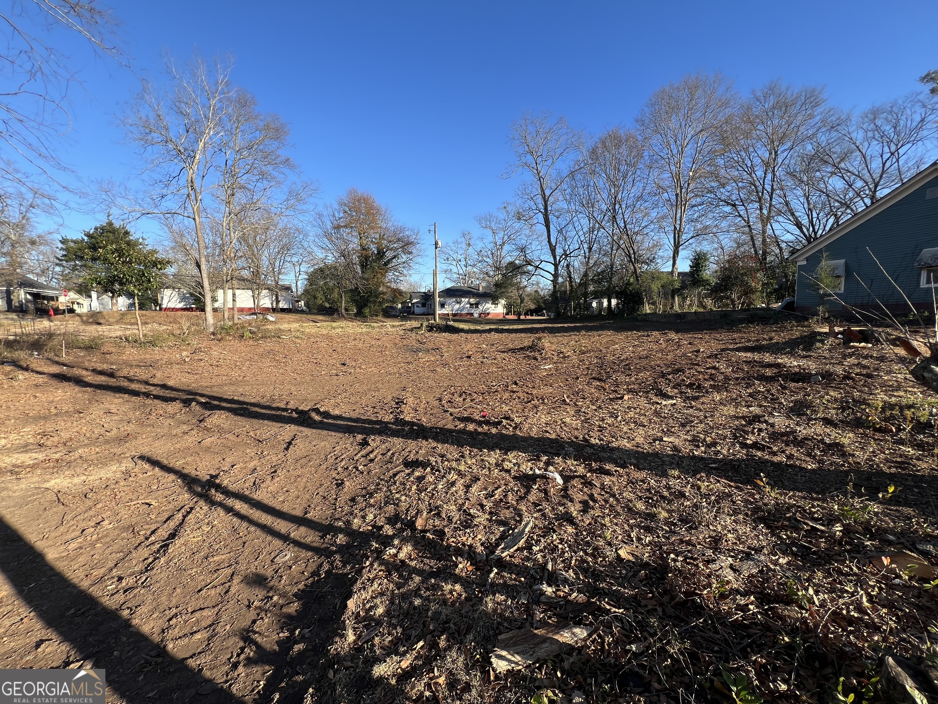 a view of a dry yard with wooden fence