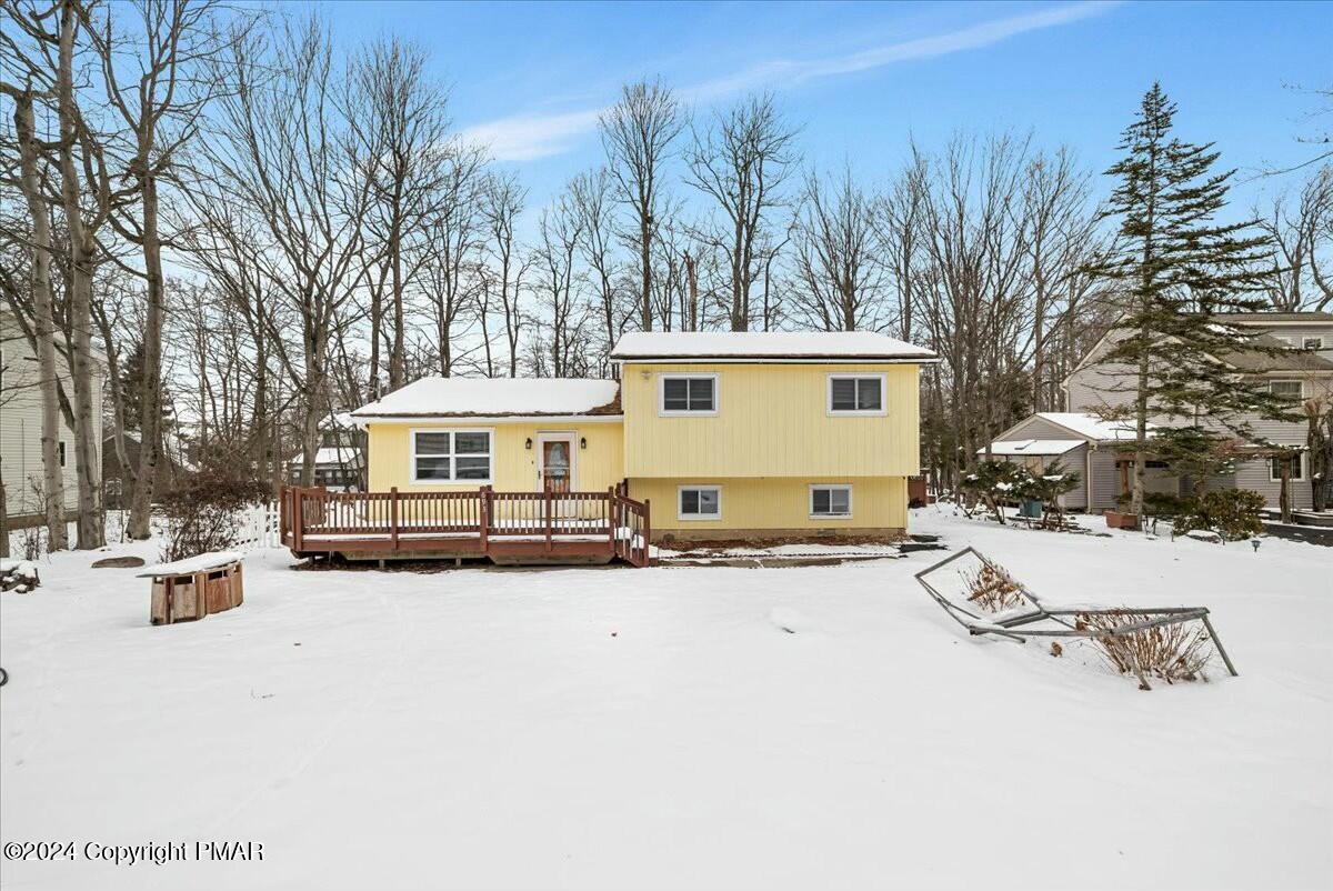 a front view of a house with a yard covered in snow