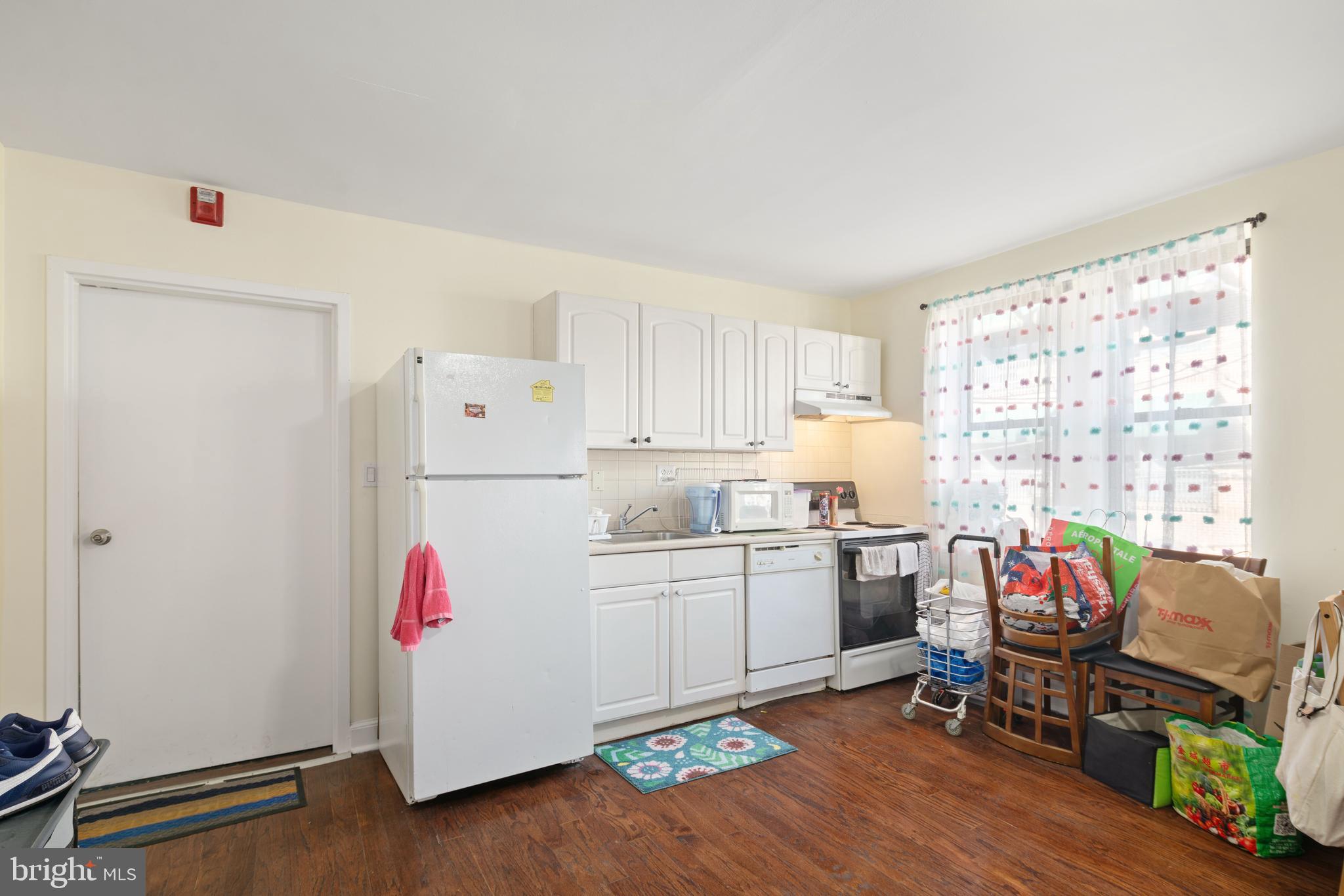 a kitchen with a refrigerator and wooden floor