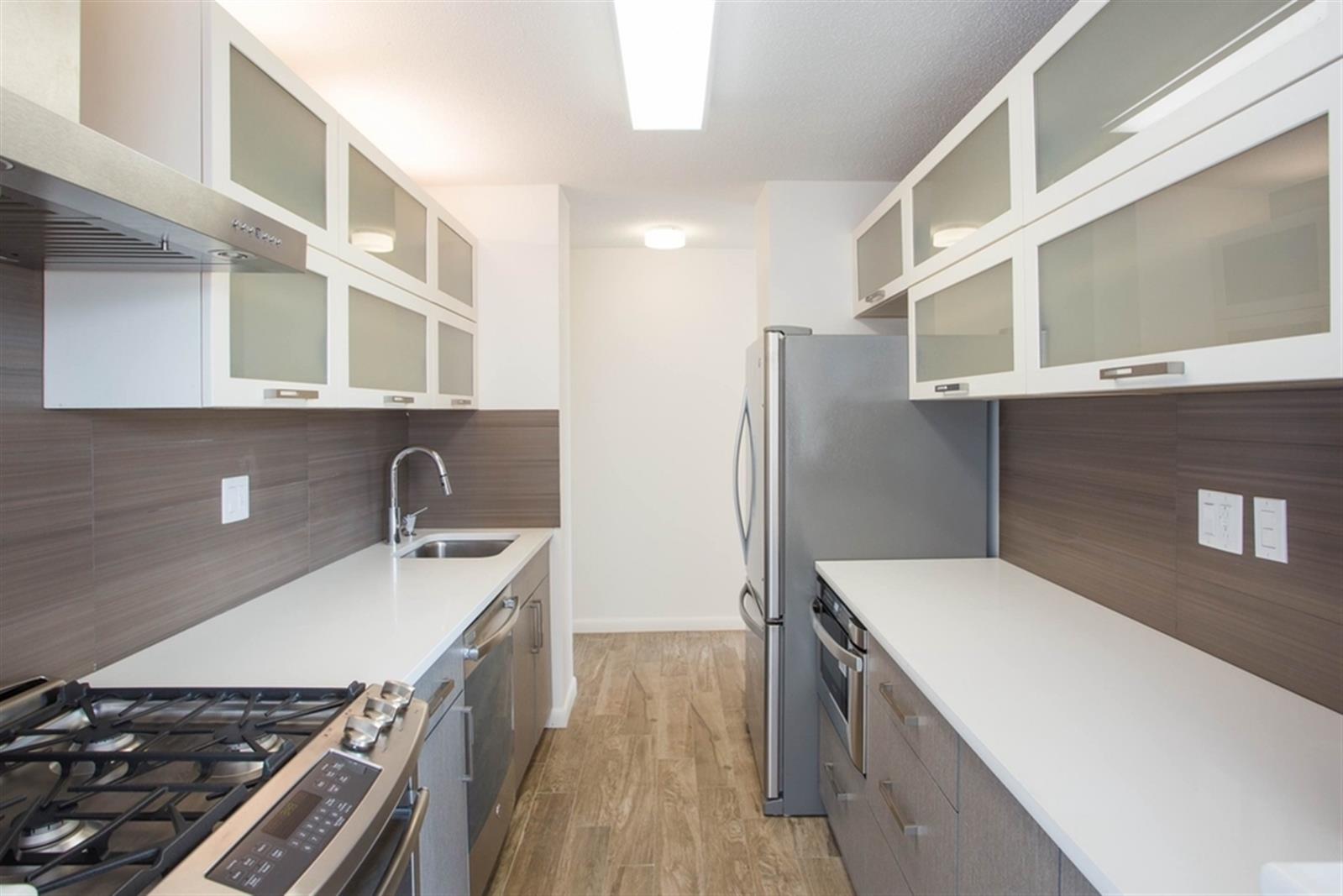 a kitchen with stainless steel appliances a sink stove and refrigerator