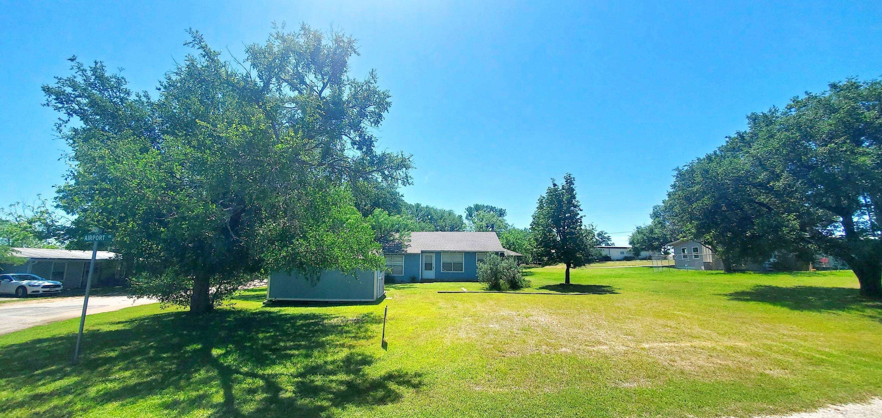 a view of a house with a yard and a park