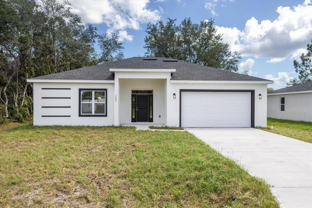 a front view of a house with a yard and garage